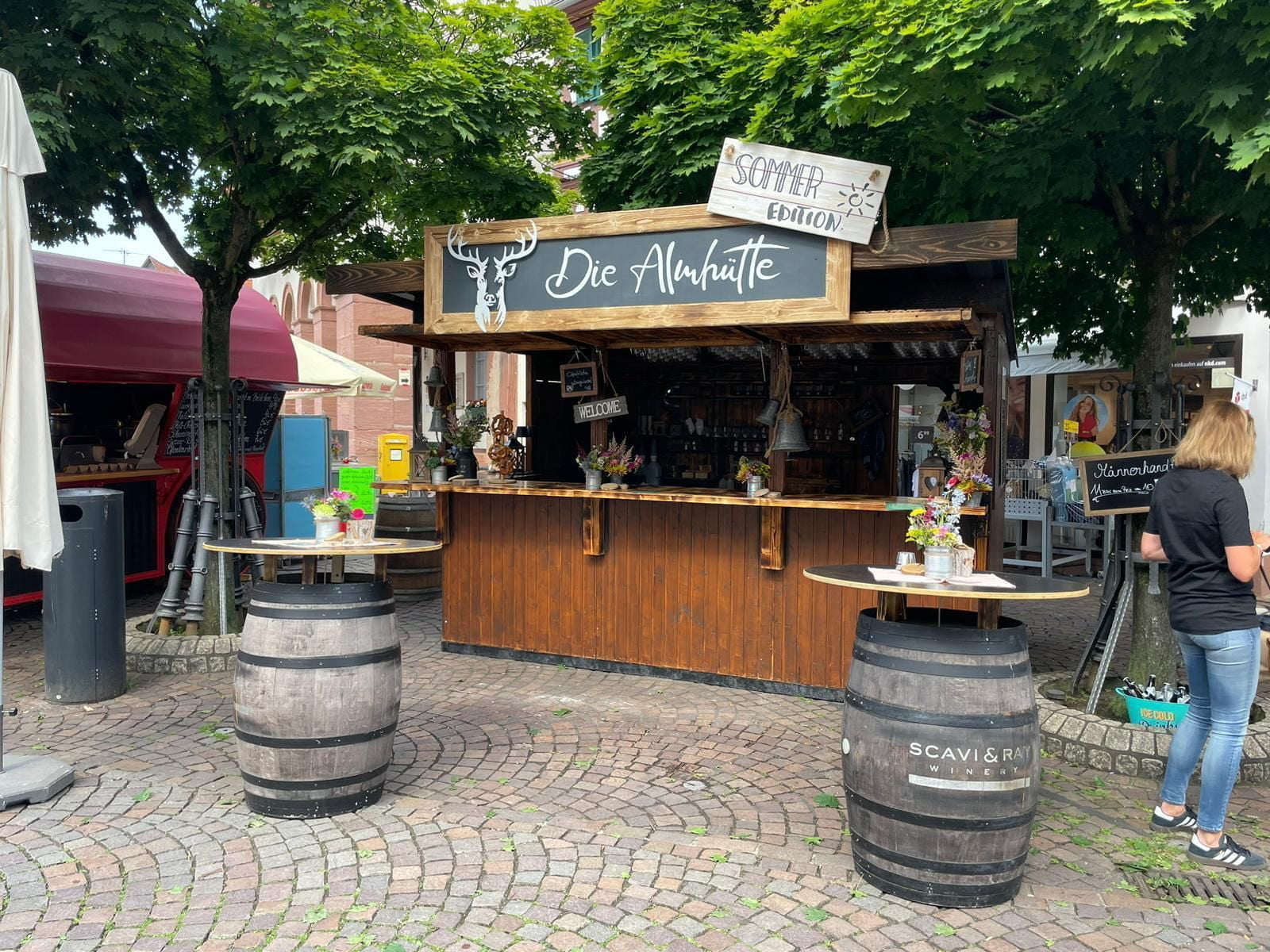 Die Almhütte im Sommer – schräg mit Weinfässern